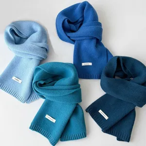 Close up detail of soft warm winter knitted wool scarf displayed in assorted blue colors.