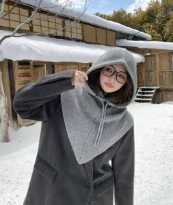 Gros plan d'une cagoule en tricot gris confortable portée en extérieur par temps de neige.
