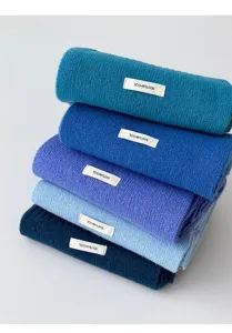 Detailed view of soft winter knitted wool scarf in various blue colors, cozy neck warmer.