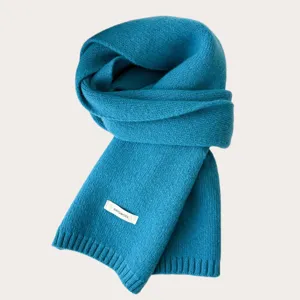 Close-up of a soft winter knitted wool scarf in turquoise, warm and cozy cold weather accessory.