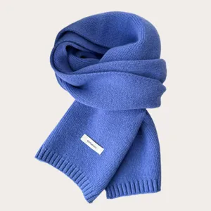 Detailed view of the cozy blue winter knit wool scarf, showing soft texture and wool material label.