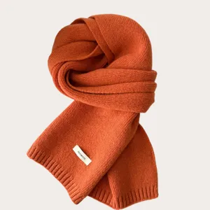 Detailed view of a soft solid color knitted wool scarf, warm winter accessory for women.