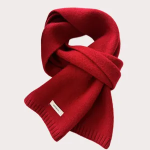 Close-up of a soft red knitted wool scarf texture, warm winter accessory detail view.