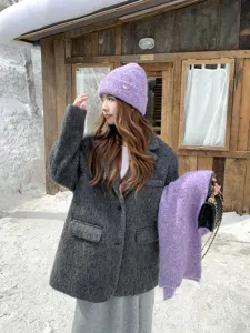 Detalle de moda invernal al aire libre con bufanda y gorro de punto morado en cabaña nevada.