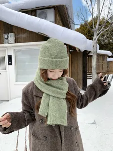 Detalle de conjunto de bufanda y gorro de punto verde, accesorio de invierno cálido y suave.