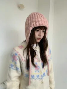 Close-up detail of the pink chunky knit balaclava hat, showing cozy earflap and warm texture.