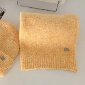 Acogedor juego de bufanda y gorro de punto amarillo con bonito detalle de metal.