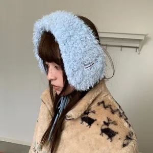 Nahaufnahme von flauschigen hellblauen Winter-Ohrschützern mit Bindebändern und Textur.