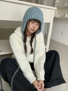 Korean style chunky knit balaclava hat detail shot, cozy winter earflap design in light blue.