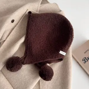 Brown wool balaclava hat with pom poms, cozy winter knitted beanie hood detail view.