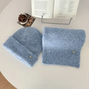 Light blue knitted beanie hat and winter warm scarf set with metal tag decoration.