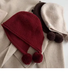 Knit wool balaclava hat with fluffy pom poms warm winter ear protection cap detail shot