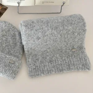 Detalle de conjunto de bufanda y gorro de punto gris, textura suave y esponjosa, etiqueta.