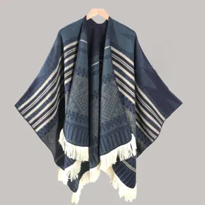 Ethnic style knitted poncho shawl for women, warm winter cape with fringe and geometric patterns.