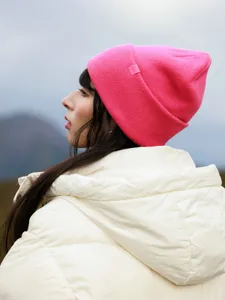 Detail view of the vibrant pink wool knit beanie, featuring a cozy cuffed design and brand tag.
