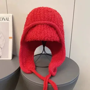 Rote Plüsch Ushanka Mütze Detailaufnahme, warme gefütterte Fliegermütze mit geflochtenen Bändern.