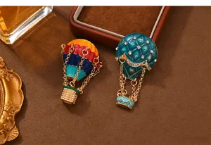 Close-up detail shot of exquisite hot air balloon brooch with enamel and crystal embellishments.