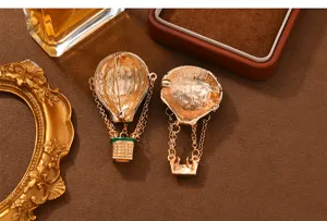 Hot air balloon brooch back detail view, gold tone metal alloy pin with delicate chain decor.