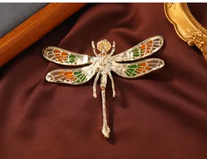 Detaillierte Rückansicht der exquisiten Libellen-Brosche aus goldfarbenem Metall mit Emaille.