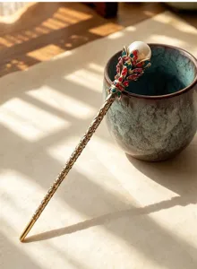 Detail shot of a vintage bronze hair stick featuring sparkling rhinestones and pearl.