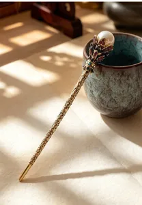 Close-up detail of vintage bronze hair stick with pearl and rhinestones for elegant styling.