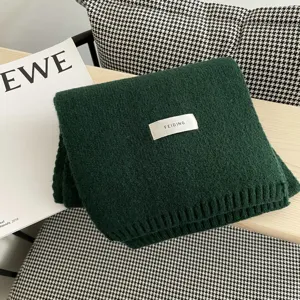 Bufanda de punto verde oscuro lisa con etiqueta de marca, accesorio cálido y acogedor.