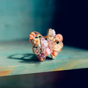 Detail shot of alloy butterfly hair claw decorated with mini soft clay roses and rhinestones.