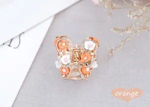 Detail shot of the butterfly alloy hair claw featuring delicate clay roses and sparkling rhinestones.