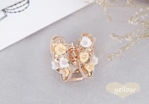 Close-up of alloy butterfly hair claw with soft pottery roses and sparkling rhinestones for cute style.