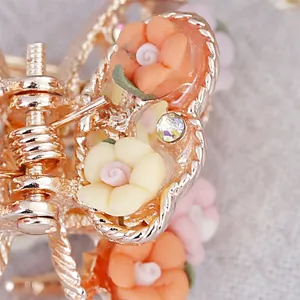 Close-up detail of vintage metal hair claw clip with colorful soft pottery flowers rhinestones.