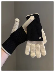 Gros plan détaillé de gants en tricot bicolore sans doigts avec rabat convertible pour l'hiver.