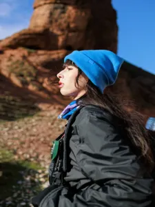 Close-up detail shot of a solid blue knit beanie hat for women, warm winter outdoor headwear.
