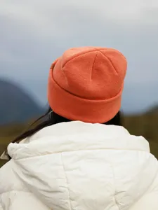 Detail view of women's 100% pure wool warm cuffed knit beanie hat in coral orange color.