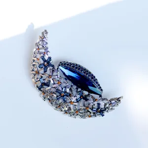 Close-up of vintage crystal moon brooch with detailed blue marquise main stone.