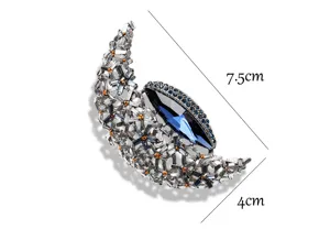Detailed close-up view of vintage crystal rhinestone crescent moon brooch pin sparkle jewelry.