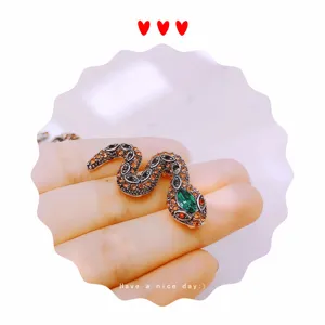 Vintage rhinestone snake brooch close-up, detailed metal and crystal inlay design.