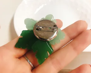Detailed back view of the green glass flower brooch showing metal pin and fine craftsmanship.