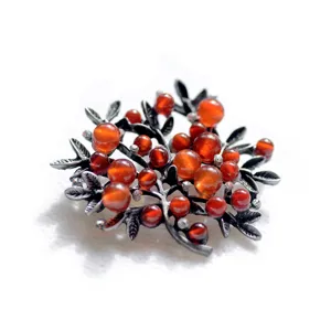 Vintage oxidized metal branch brooch with rich red round beads, elegant sweater scarf accessory.