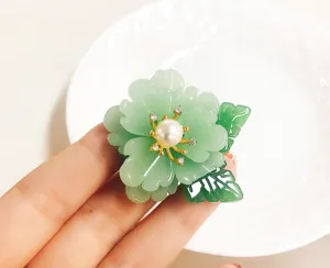 Green imitation glass flower brooch with freshwater pearl detail, elegant vintage jewelry pin.
