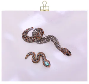 Detailed close-up view of vintage rhinestone snake brooch set, featuring crystal pavé.