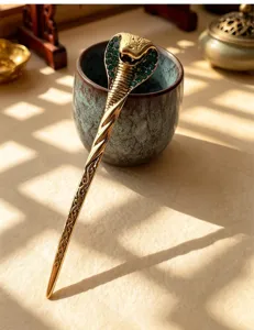 Close-up view of vintage gold cobra hair stick with green rhinestones for chic styling.