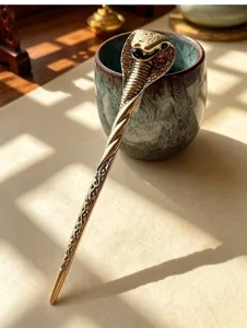 Detail shot of vintage metal cobra hairpin with rhinestone inlay for elegant hair styling.