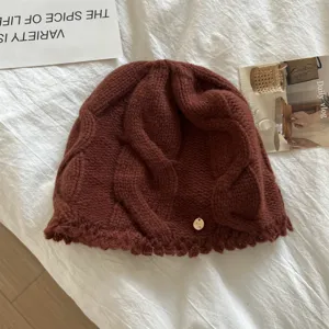 Detailed view of women's cable knit wool beanie, cozy chocolate brown winter thermal hat.