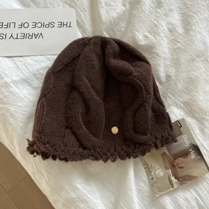 Detailed view of women's brown cable knit woolen beanie, showing soft winter warm texture.