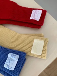 Detailansicht der koreanischen einfarbigen Strick-Wollstulpen mit hübschen Webetiketten.