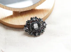 Primo piano della spilla di cristallo barocco vintage con strass neri brillanti e lega.