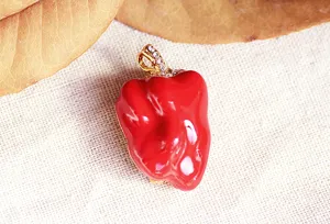 Red enamel bell pepper brooch detail, gold-tone metal and sparkling rhinestone accents.
