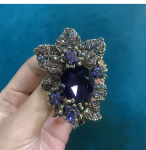 Vintage crystal glass brooch detailed close-up, retro rhinestone flower lapel pin accessory.