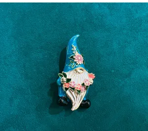 Enamel gnome brooch featuring a blue hat and floral details, perfect vintage clothing accessory pin.