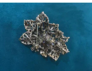 Detailed view showing the back pin mechanism and metallic texture of the vintage leaf brooch.